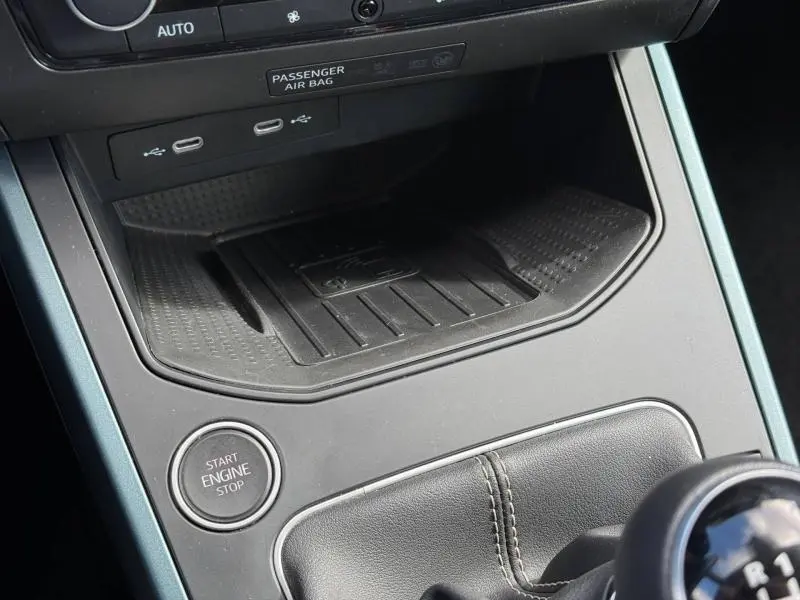 Détail de la console centrale du SEAT Arona 2025, montrant le bouton start/stop et la zone de recharge sans fil.