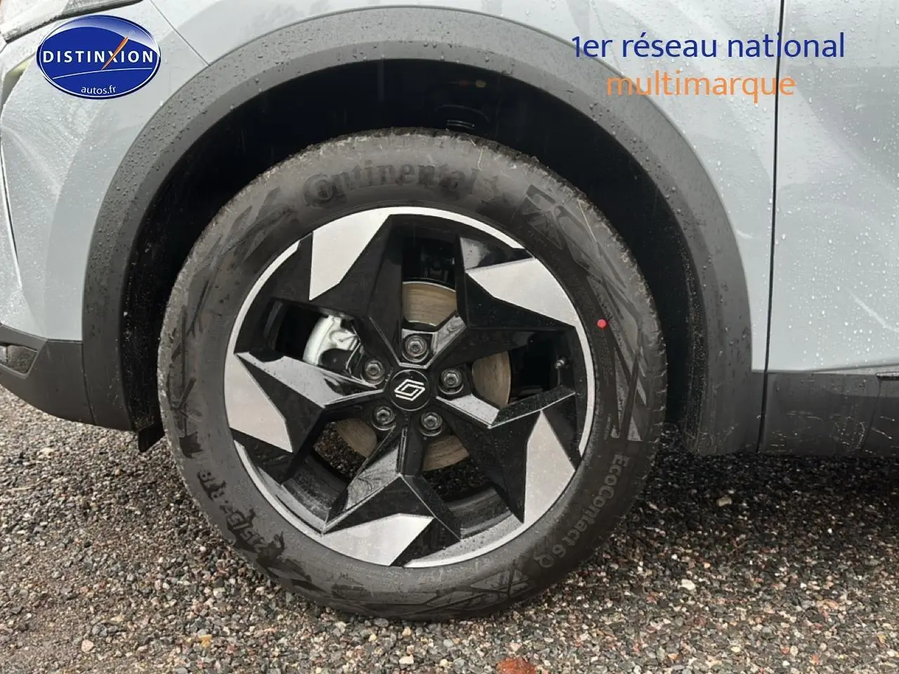 Gros plan sur la roue avant gauche du Renault Captur gris rafale avec jante alu au design géométrique noir et argent.