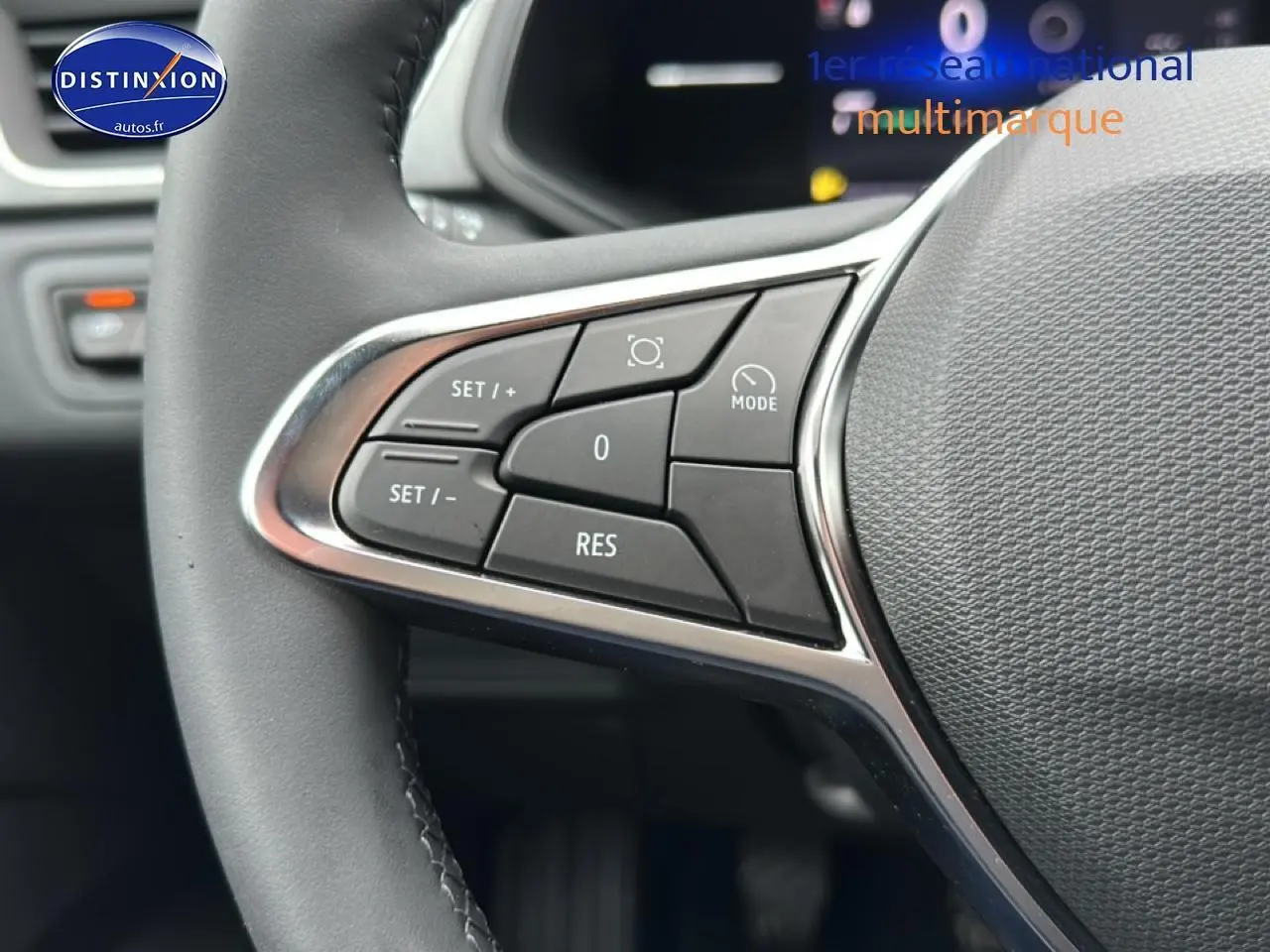 Gros plan sur les commandes multifonctions à gauche du volant du Renault Captur gris rafale, version 2025.