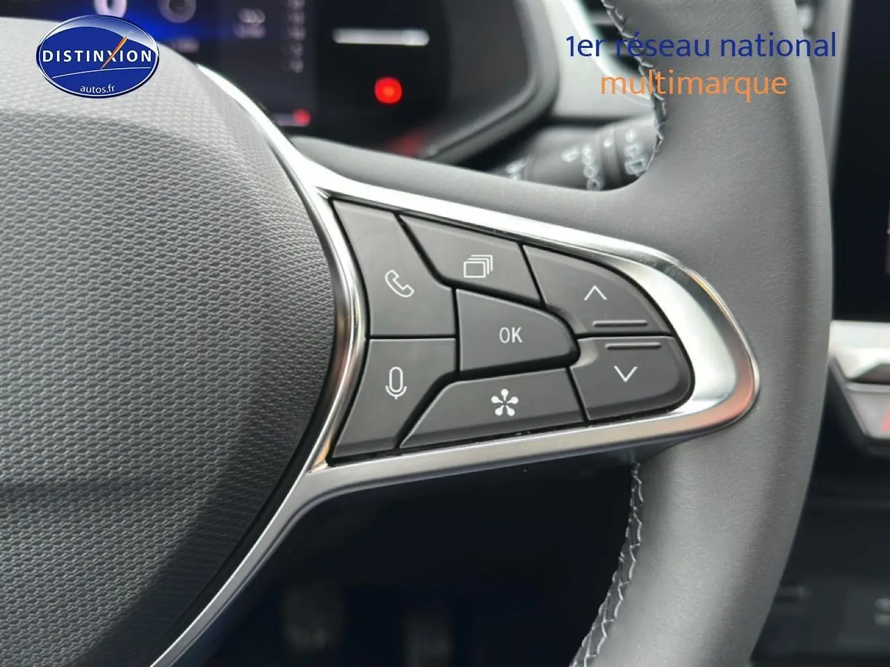 Gros plan sur les commandes multifonctions à droite du volant cuir noir du Renault Captur gris rafale 2025.