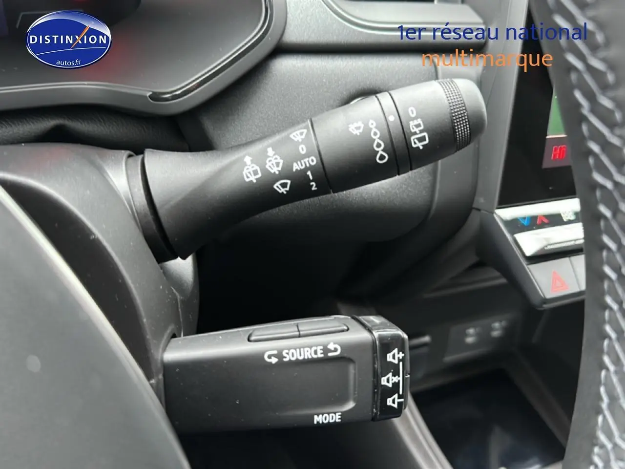 Gros plan sur les commandes au volant du Renault Captur gris rafale, montrant les leviers de clignotants et audio.