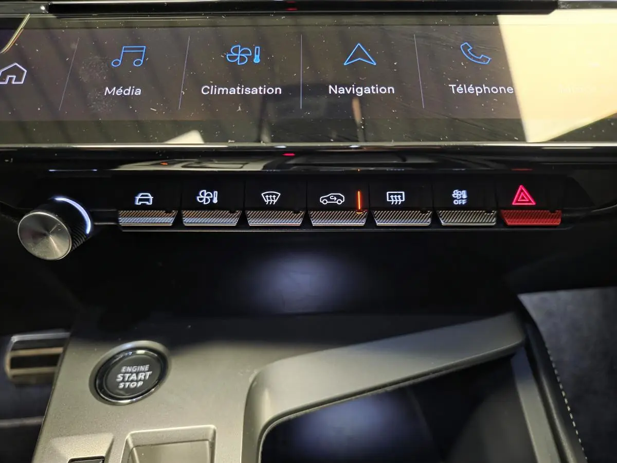 Vue rapprochée de la console centrale du Peugeot 408 gris, montrant les commandes tactiles et le bouton start/stop.