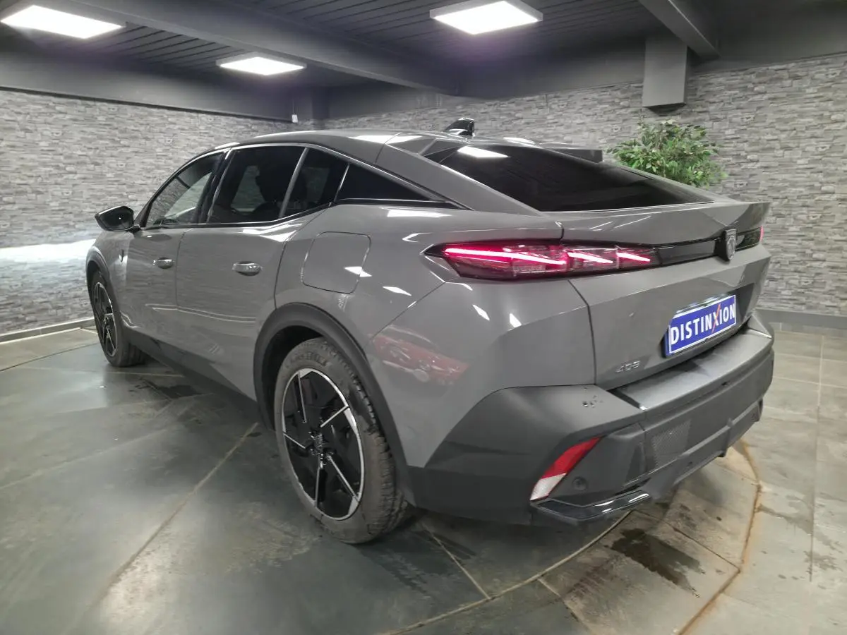Peugeot 408 gris Selenium vue 3/4 arrière droit, feux arrière LED allumés et jantes alliage 19 pouces.