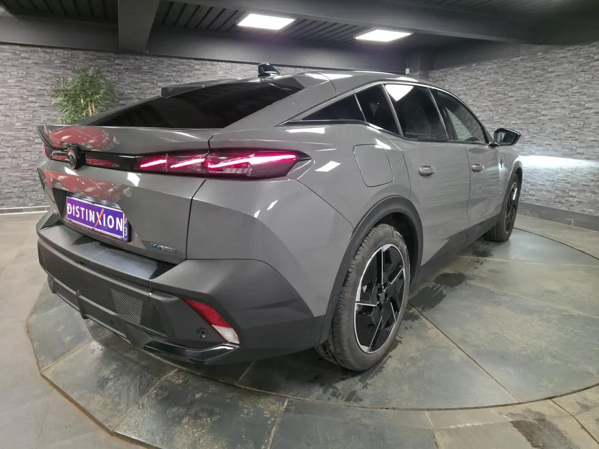 Vue 3/4 arrière droit d'une Peugeot 408 gris métallisé avec feux arrière LED en forme de griffe et jantes alliage 19 pouces.