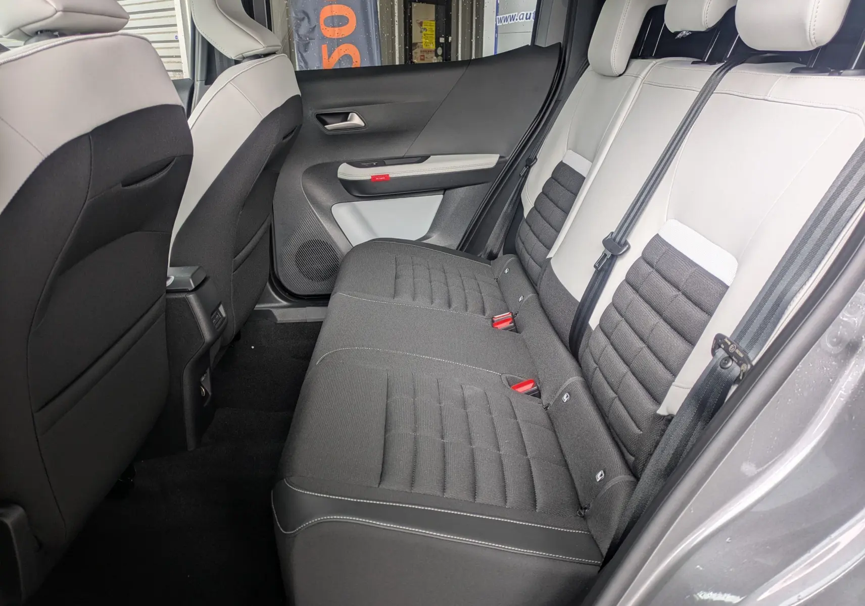 Vue latérale droite de la banquette arrière bicolore gris clair et noir du Citroën C3 Aircross 2026, intérieur spacieux et moderne.