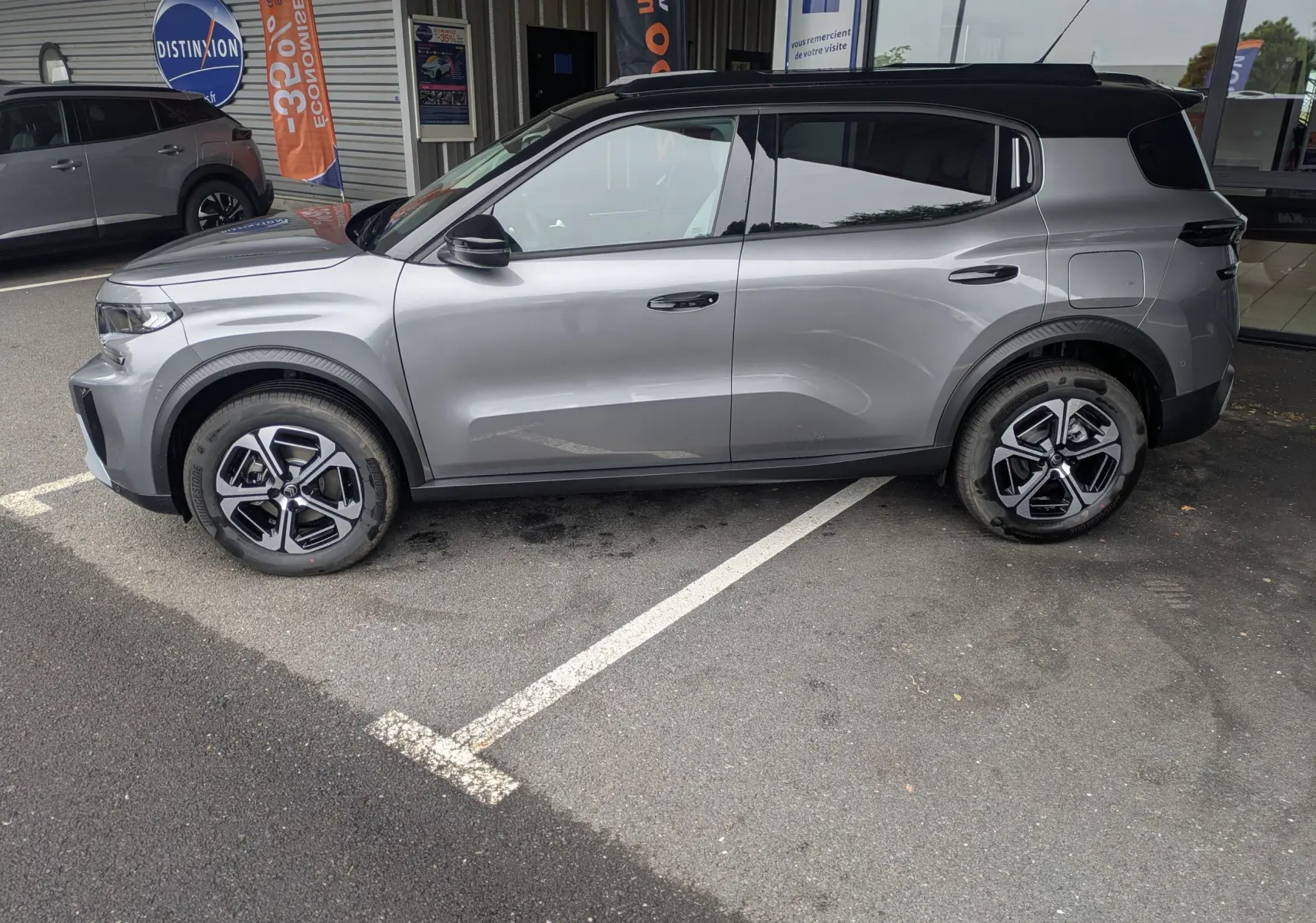 Vue de profil côté gauche du Citroën C3 Aircross gris Mercuy avec toit noir, roues alliage et lignes modernes.