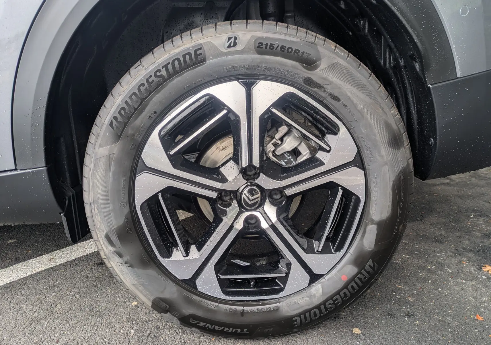 Gros plan sur la roue avant droite du Citroën C3 Aircross gris Mercuy avec jante alliage noire et argentée.