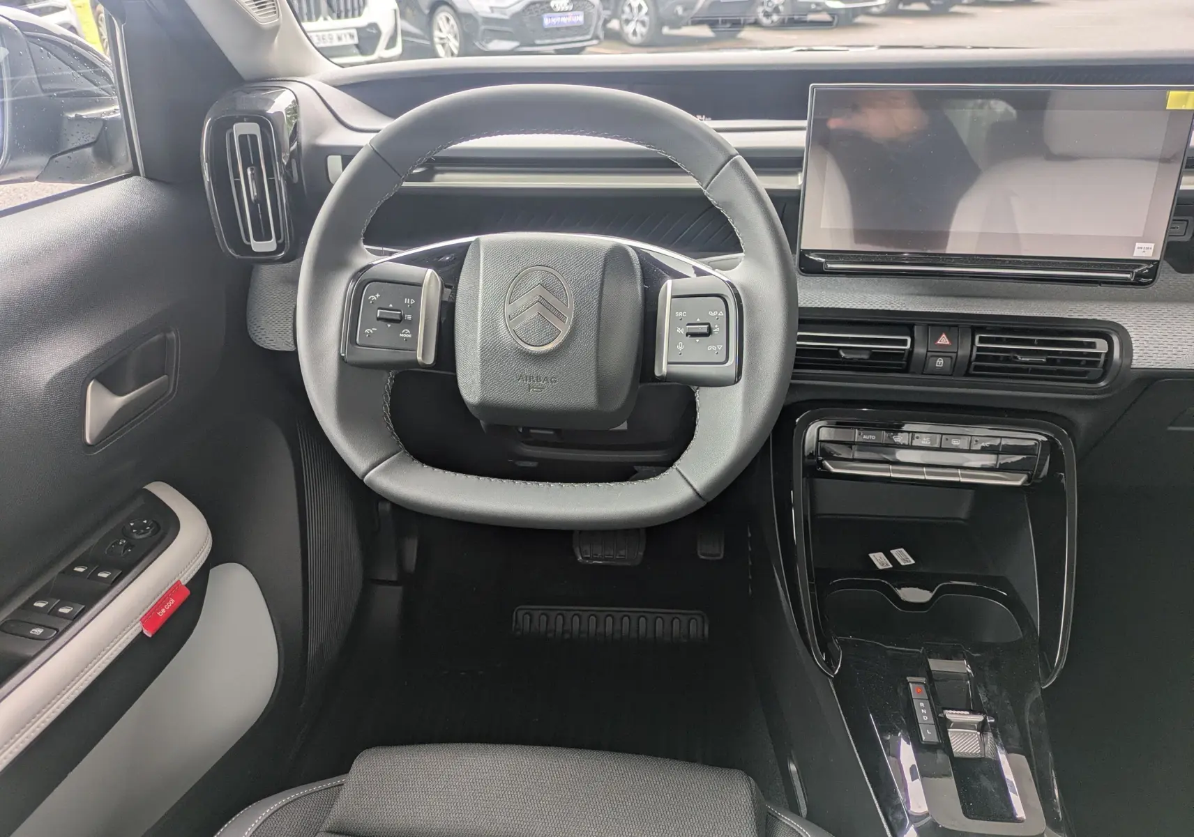 Vue intérieure centrée sur le volant et la console centrale du Citroën C3 Aircross 2026, avec écran tactile et commandes intégrées.