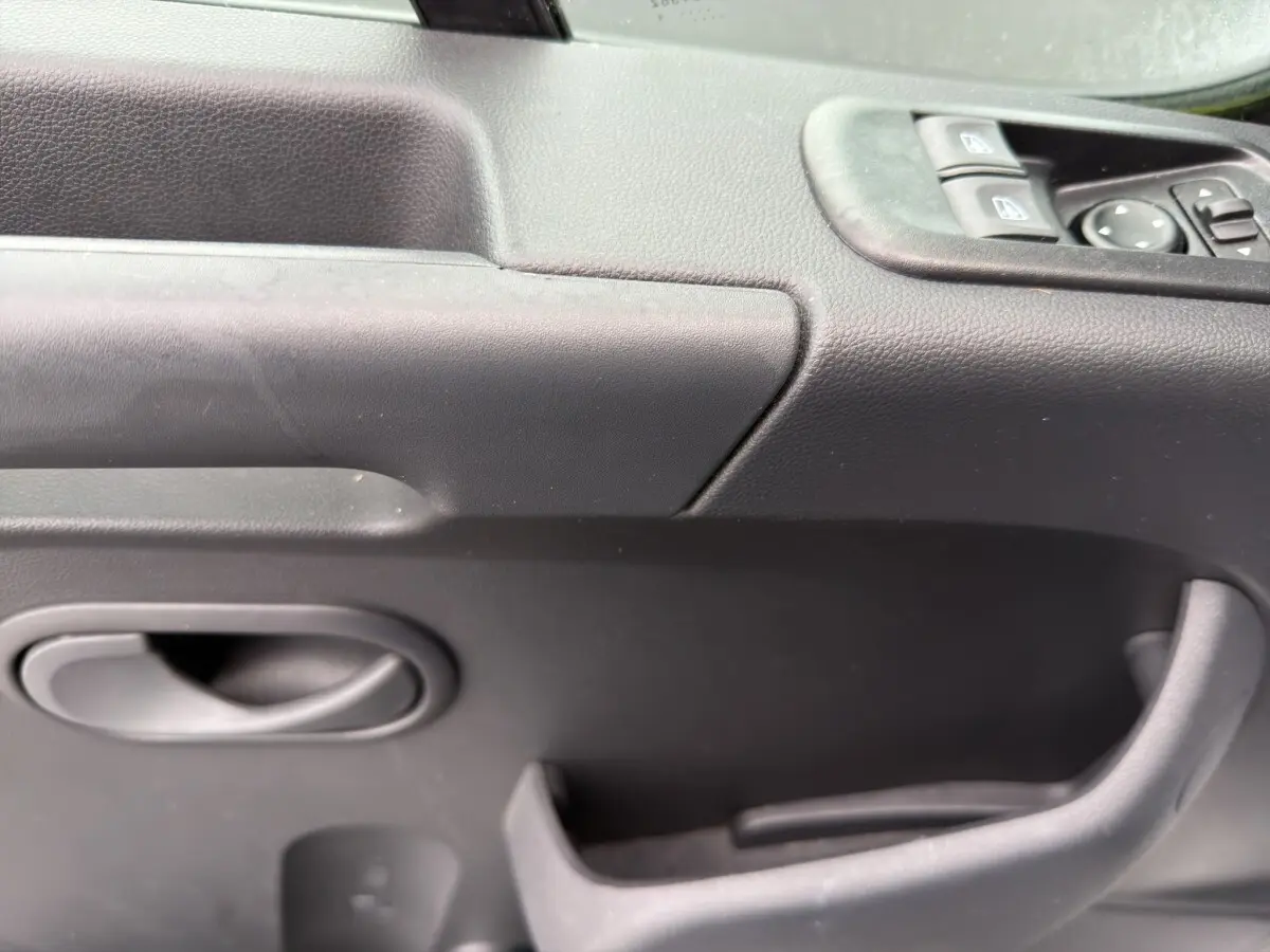 Gros plan sur la porte intérieure côté conducteur du Renault Master 2024, avec commandes de vitres électriques et poignée noire.