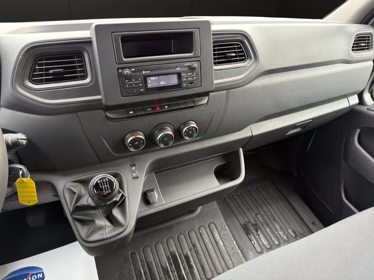 Vue intérieure côté conducteur du tableau de bord noir du Renault Master 2024 avec boîte manuelle et commandes centrales.