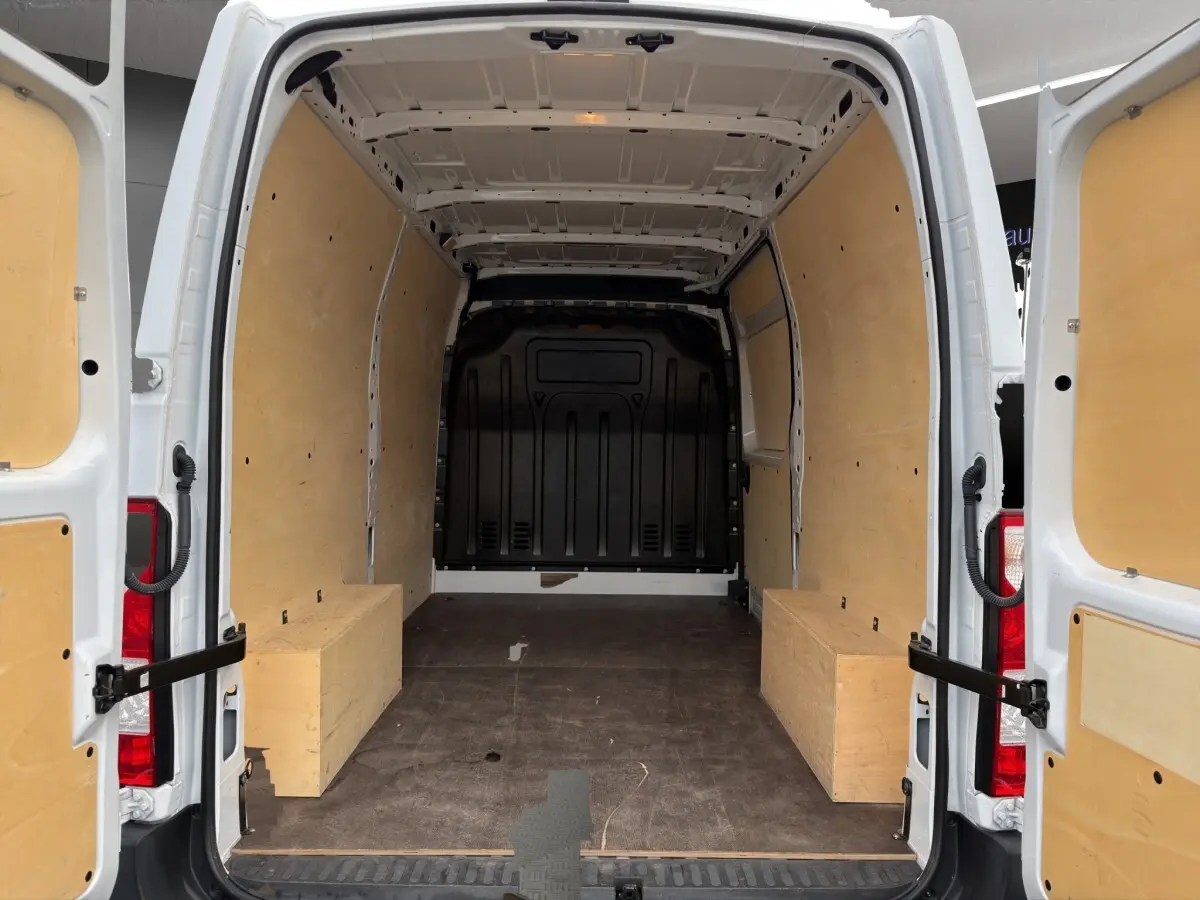 Vue arrière du Renault Master blanc 2024 avec portes ouvertes, montrant l'intérieur de chargement équipé d'un kit bois complet.