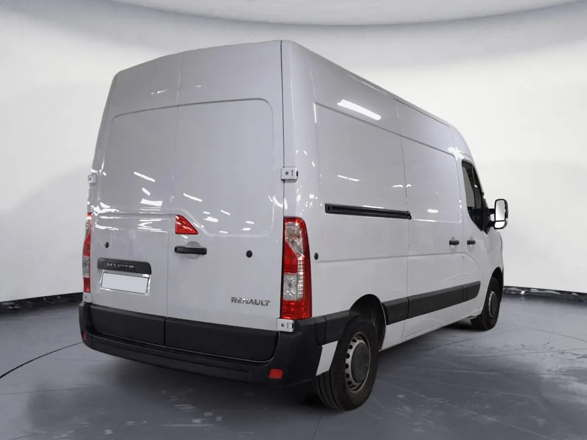 Vue 3/4 arrière droite d’un Renault Master blanc utilitaire avec portes arrière pleines et protections noires.