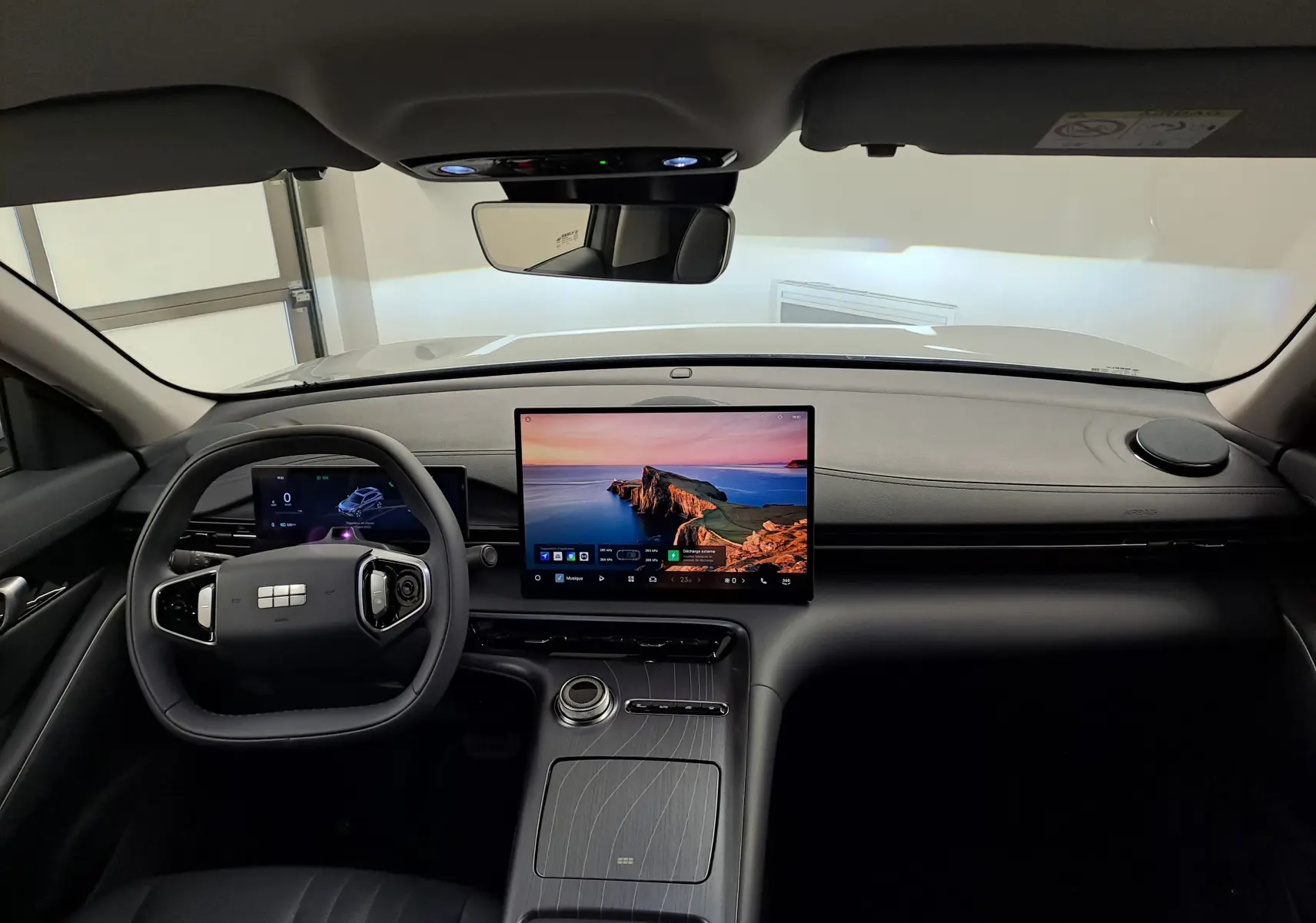 Vue intérieure avant du Geely E5 PRO 2026 gris Moonlight, avec grand écran tactile central et volant multifonction.