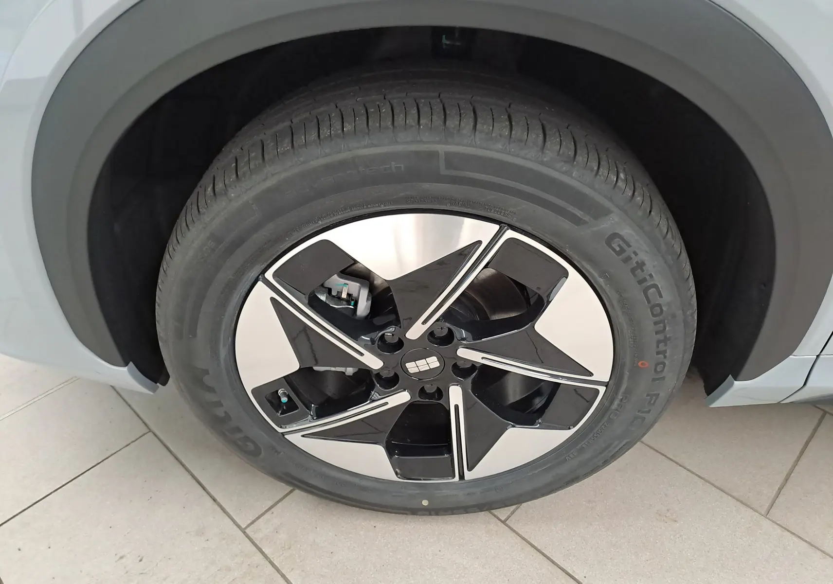 Gros plan sur la roue avant gauche du Geely E5 PRO gris Moonlight, avec jante noire et argentée au design moderne.