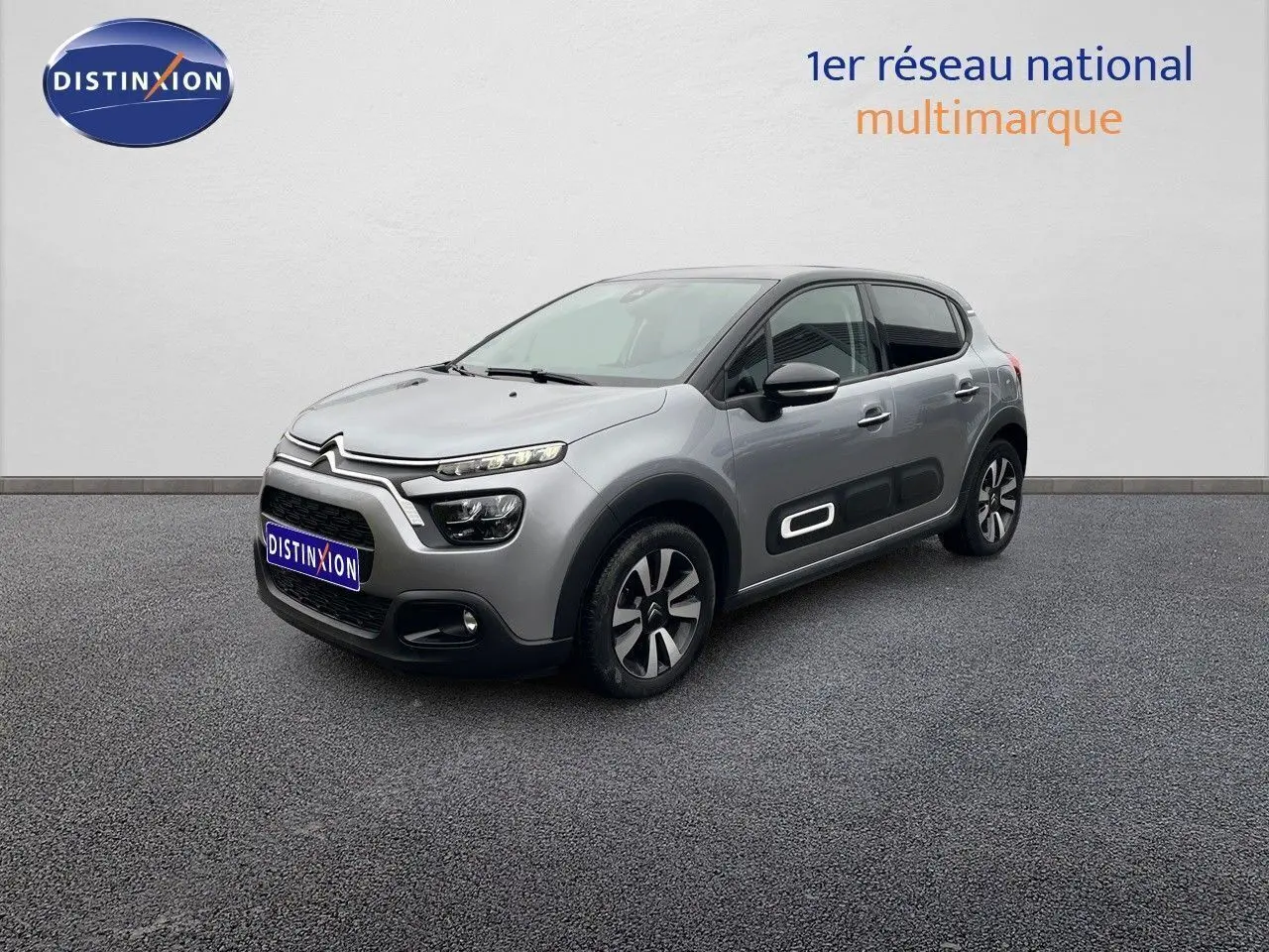 Citroën C3 gris acier métal en 3/4 avant droit, avec protections latérales noires et jantes bi-ton.