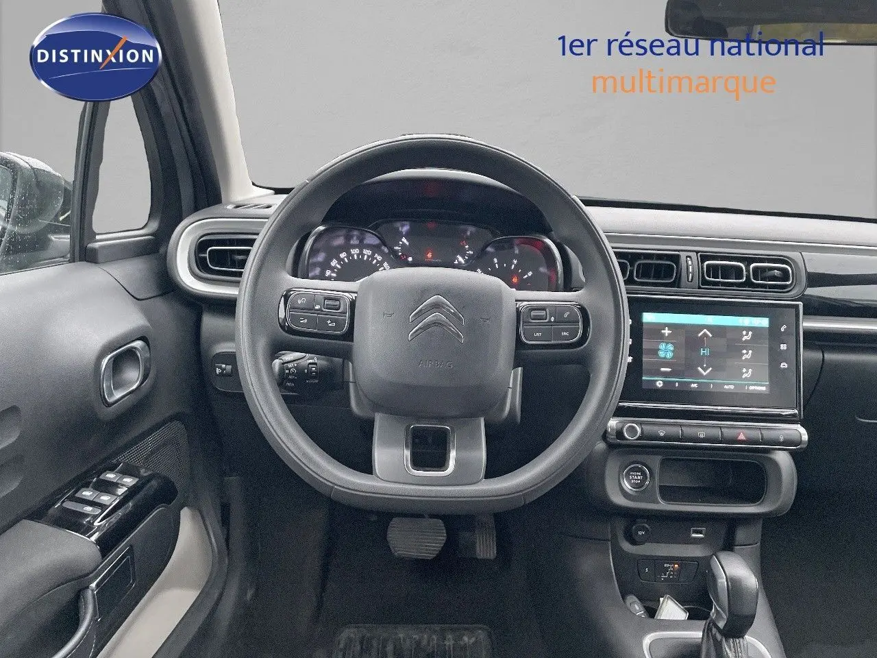 Vue frontale de l'intérieur de la Citroën C3 2023 gris acier, avec tableau de bord numérique et écran tactile central.