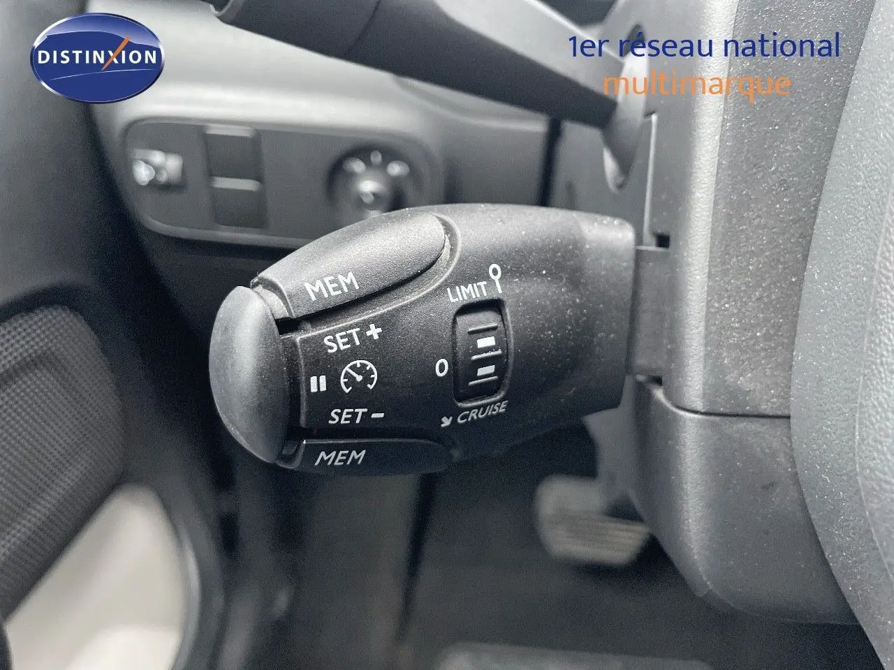 Gros plan sur la commande de régulateur de vitesse noire dans l'habitacle d'une Citroën C3 gris acier 2023