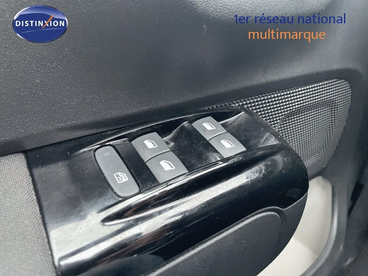 Gros plan sur les commandes des vitres électriques côté conducteur d'une Citroën C3 gris acier métal 2023.