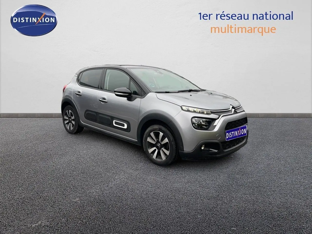 Citroën C3 gris acier métal vue 3/4 avant droit, avec protections latérales noires et jantes bi-ton.