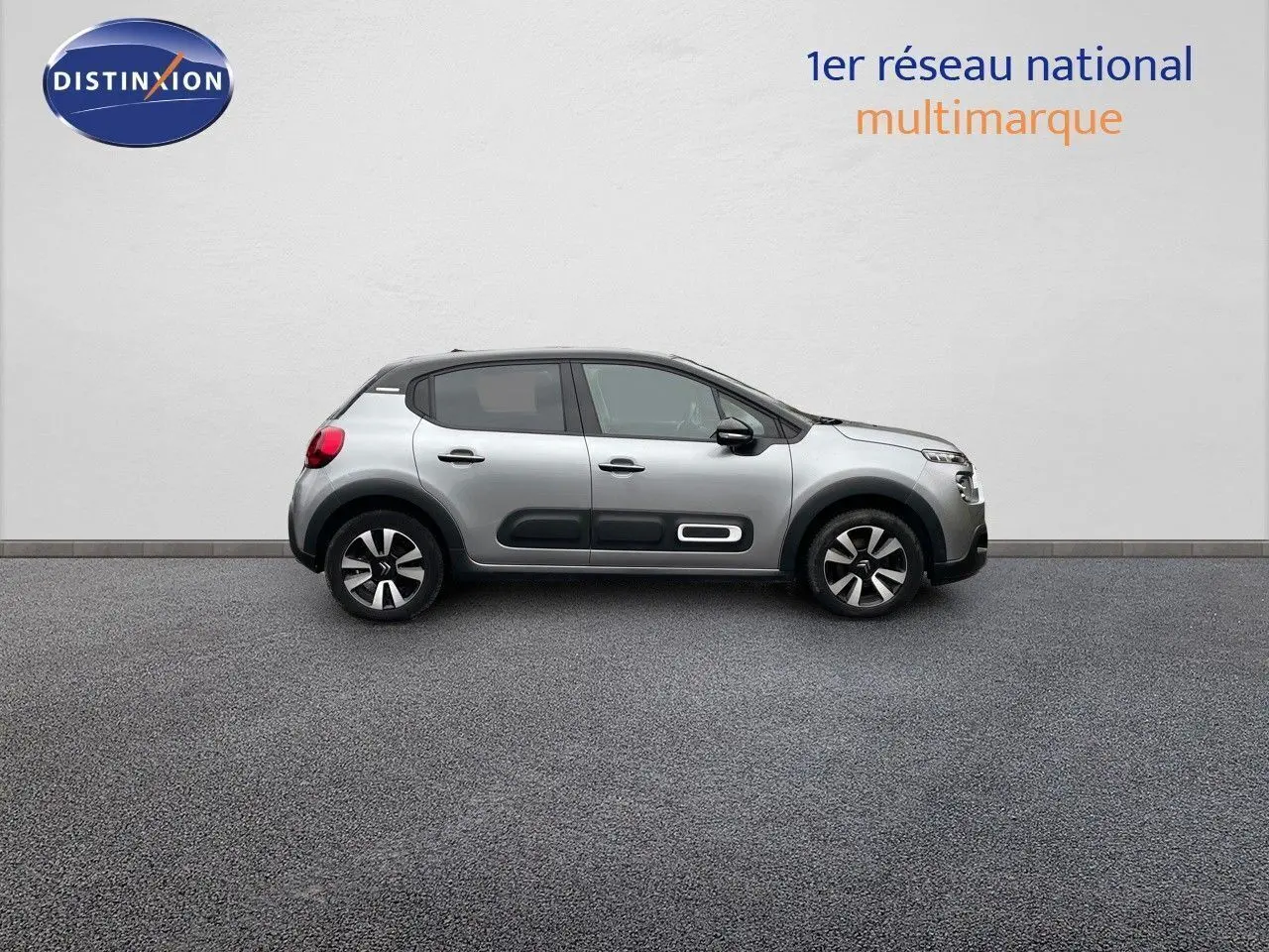 Profil côté droit d'une Citroën C3 2023 gris acier métal avec protections latérales noires et toit noir contrasté.