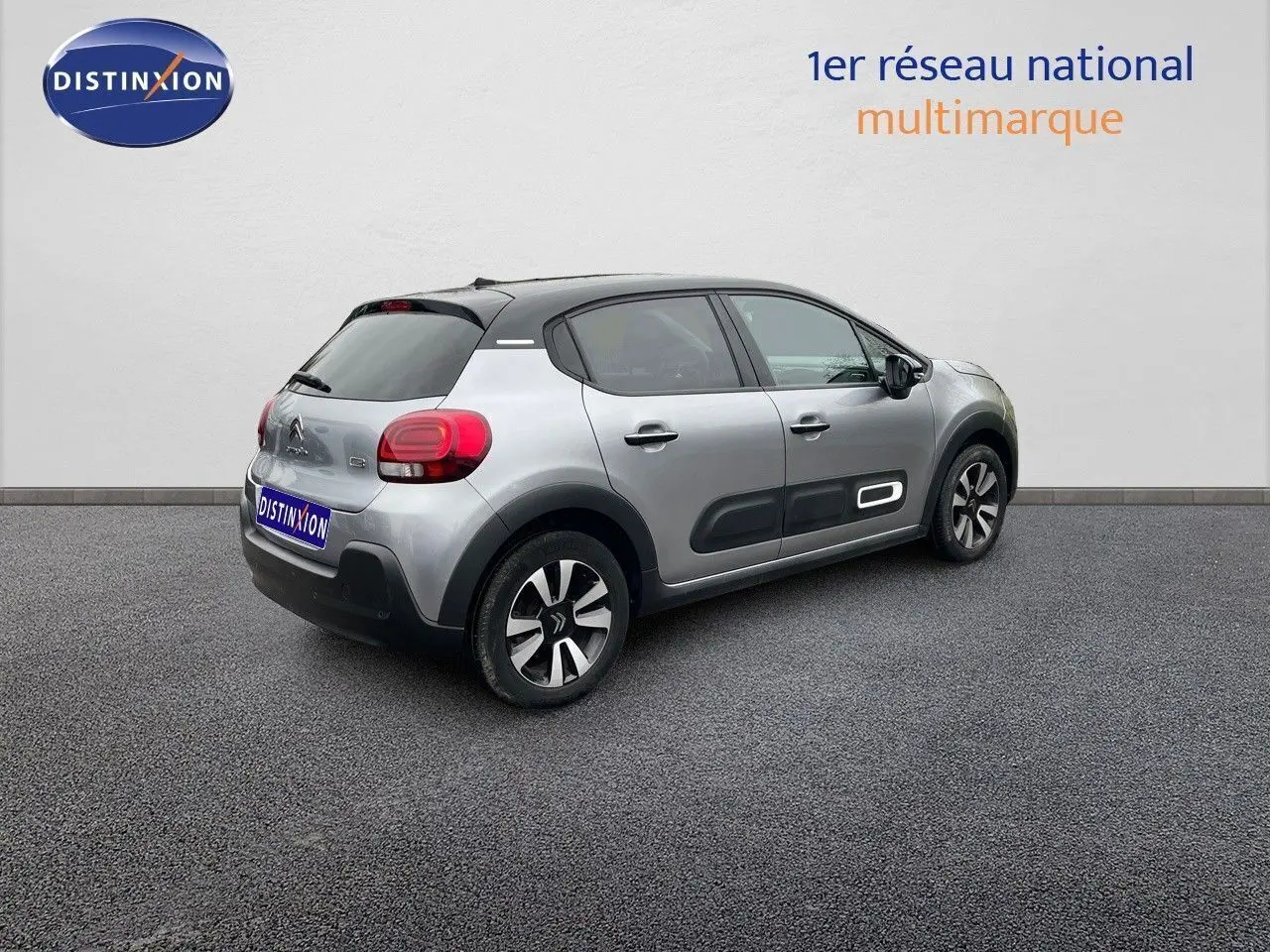 Citroën C3 gris acier métal vue 3/4 arrière côté droit, avec toit noir et protections latérales noires.