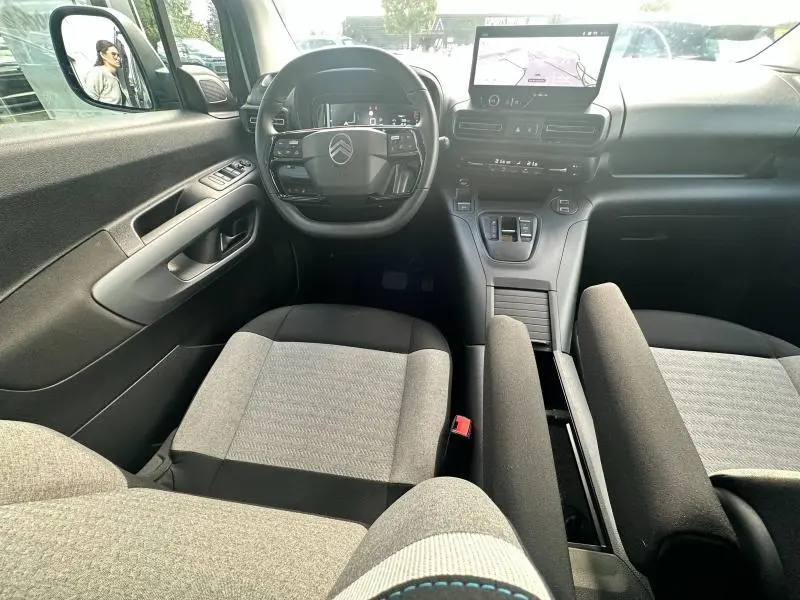 Intérieur du Citroën Berlingo 2024 vu de face, avec volant multifonction, écran tactile et sièges tissu gris.