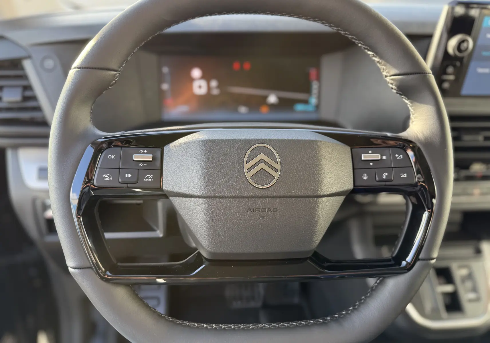 Gros plan sur le volant en cuir du Citroën Jumpy Cabine Approfondie 2025, avec commandes intégrées et logo central.