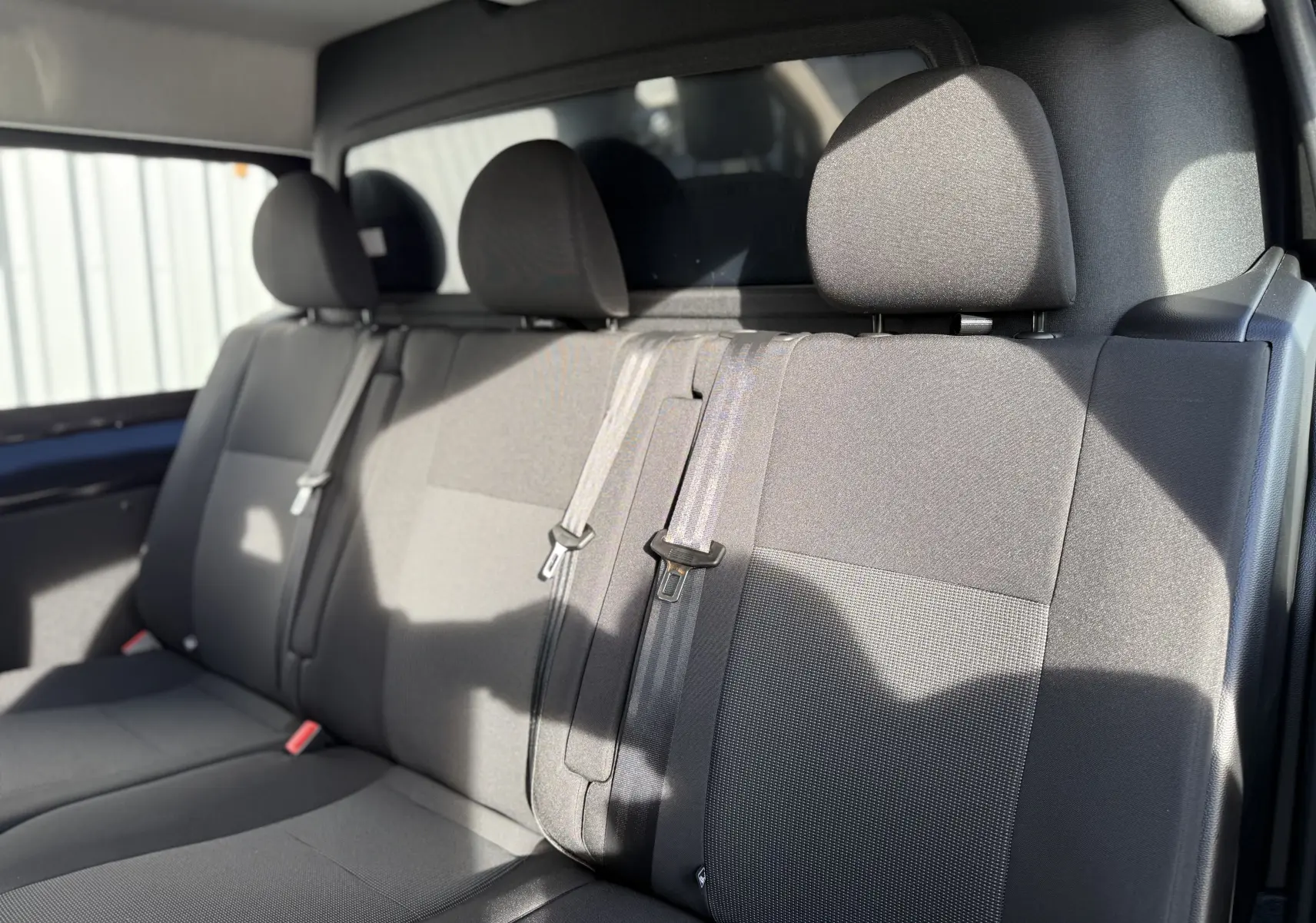 Banquette arrière en tissu gris foncé vue de côté droit dans un Citroën Jumpy Cabine Approfondie noir Perla 2025.