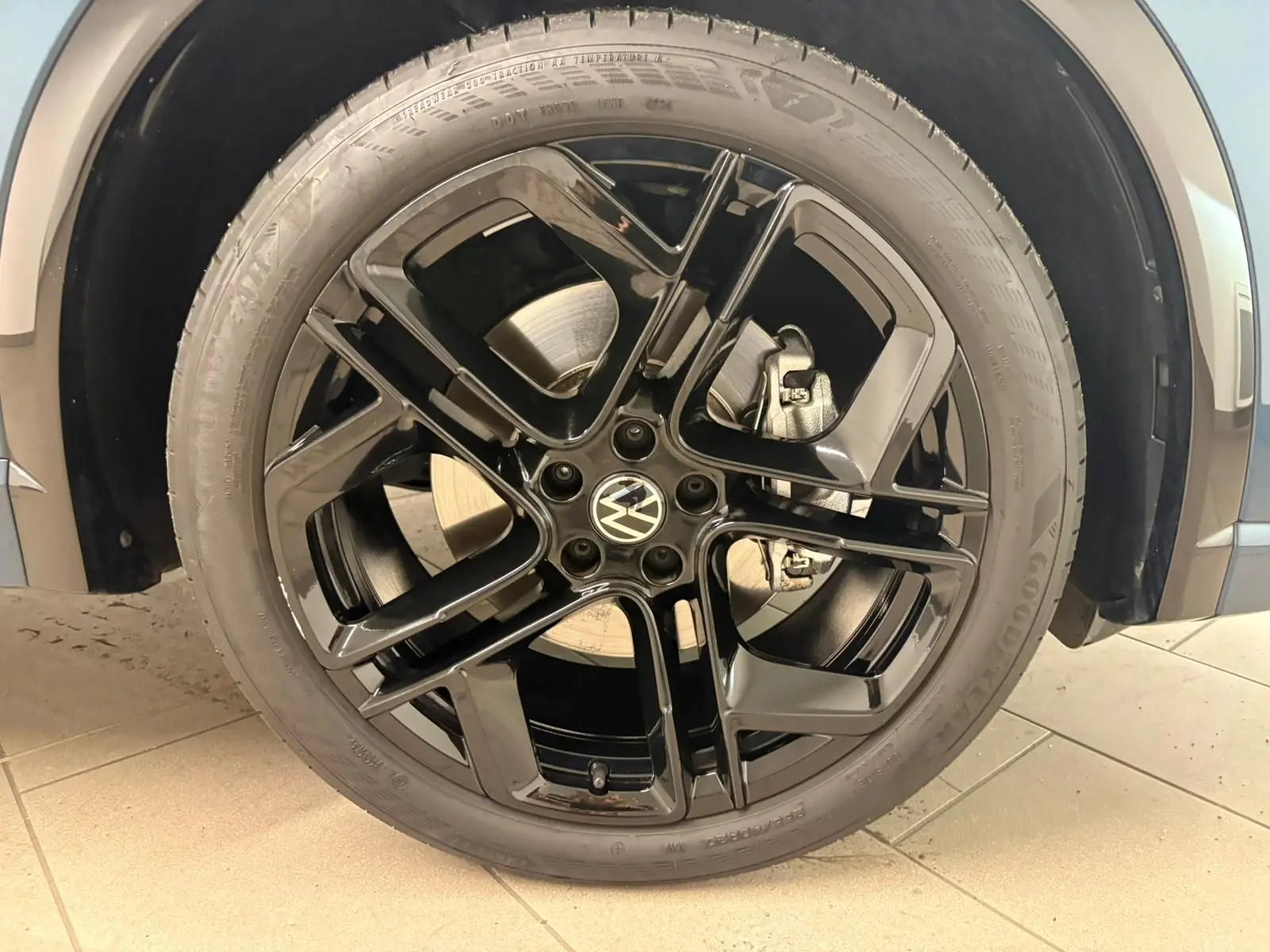 Gros plan sur la jante noire 20 pouces York du Volkswagen Tiguan Nightshade Blue, avec pneu Goodyear visible.