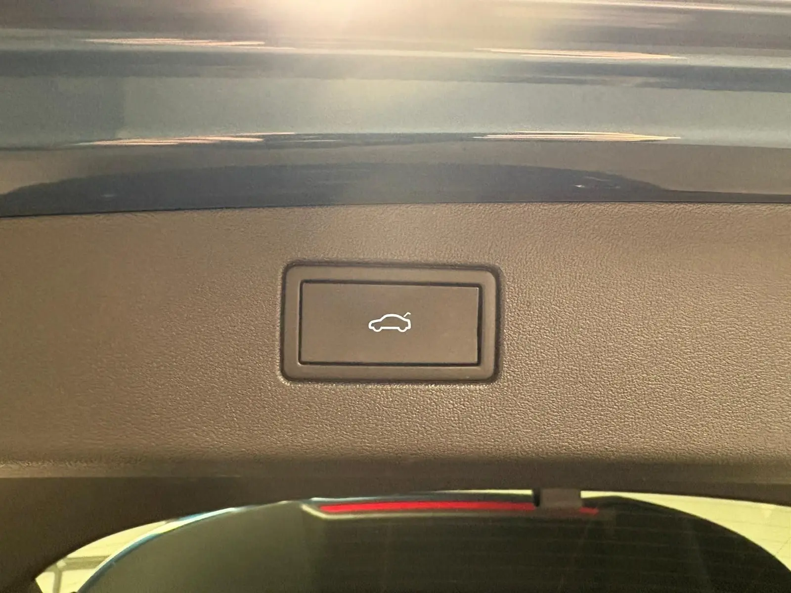 Bouton d'ouverture électrique du hayon sur le coffre du Volkswagen Tiguan Nightshade Blue, vue intérieure arrière.