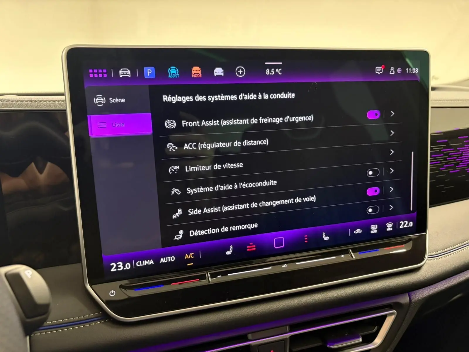 Écran tactile central du Volkswagen Tiguan 2024 affichant les réglages des aides à la conduite, intérieur noir avec surpiqûres bleues.