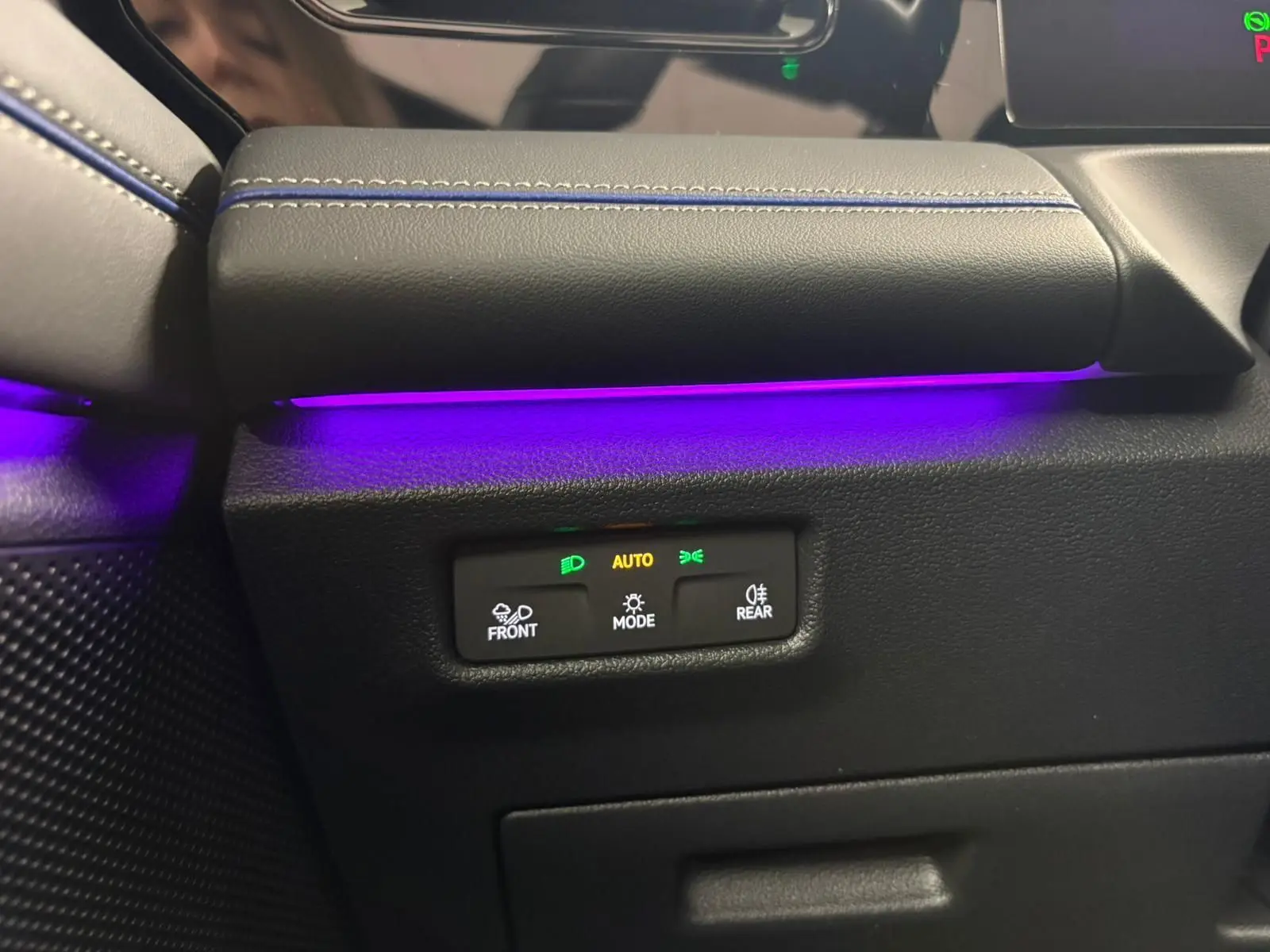 Gros plan sur la commande d’éclairage avec ambiance lumineuse violette dans l’habitacle du Volkswagen Tiguan 2024.