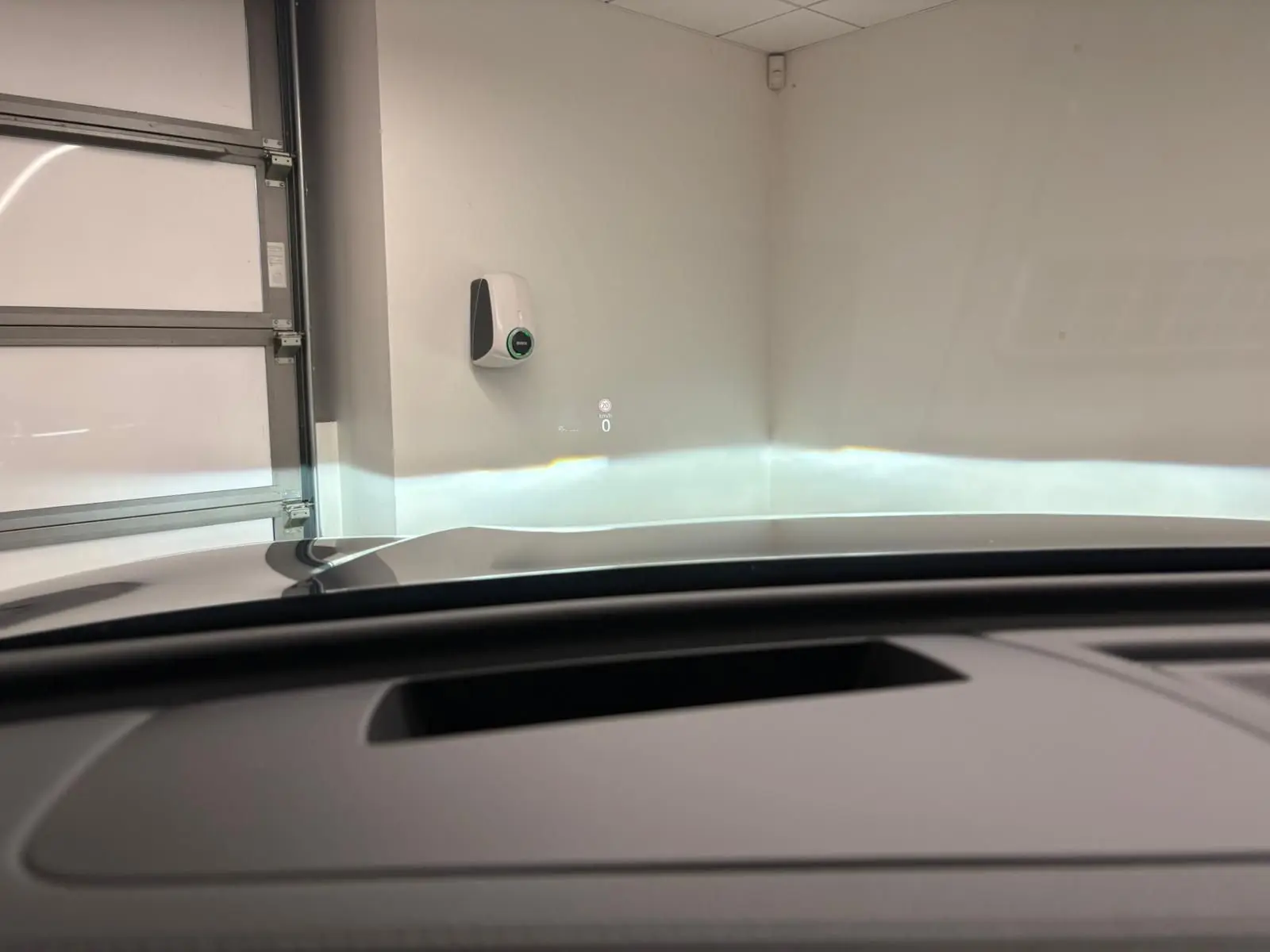 Vue intérieure du Volkswagen Tiguan 2024 avec affichage tête haute projeté sur pare-brise, toit ouvrant partiellement visible.