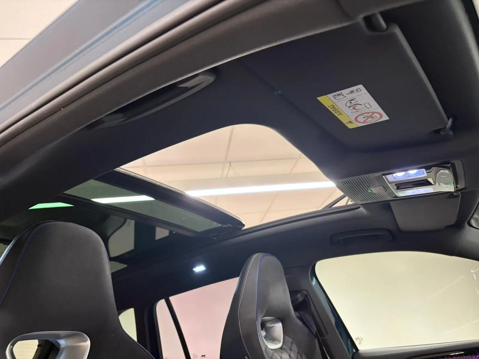 Vue plongeante sur la console centrale noire du Volkswagen Tiguan 2024 avec porte-gobelets et accoudoir entre sièges.