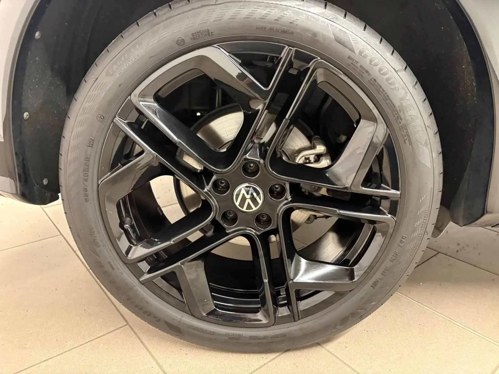 Gros plan sur la jante noire 20 pouces York du Volkswagen Tiguan Nightshade Blue, avec pneu Goodyear visible.