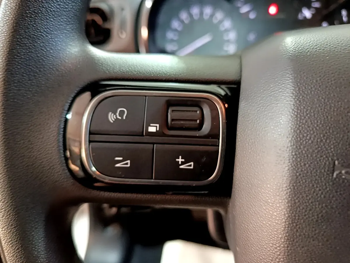 Gros plan sur les commandes vocales et volume au volant d'une Citroën C3 blanche, version Feel Business 2020.