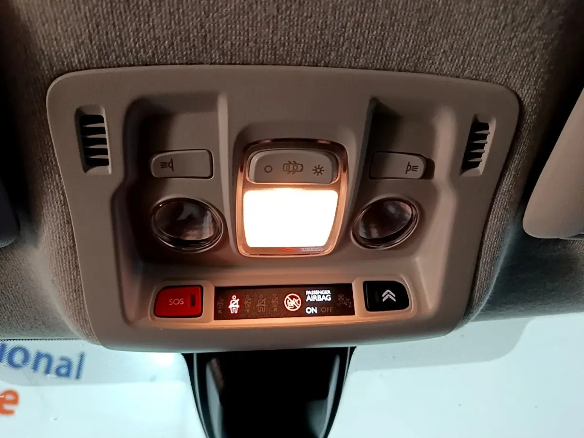Vue intérieure du plafonnier avec éclairage allumé et boutons de commande dans une Citroën C3 blanche de 2020.