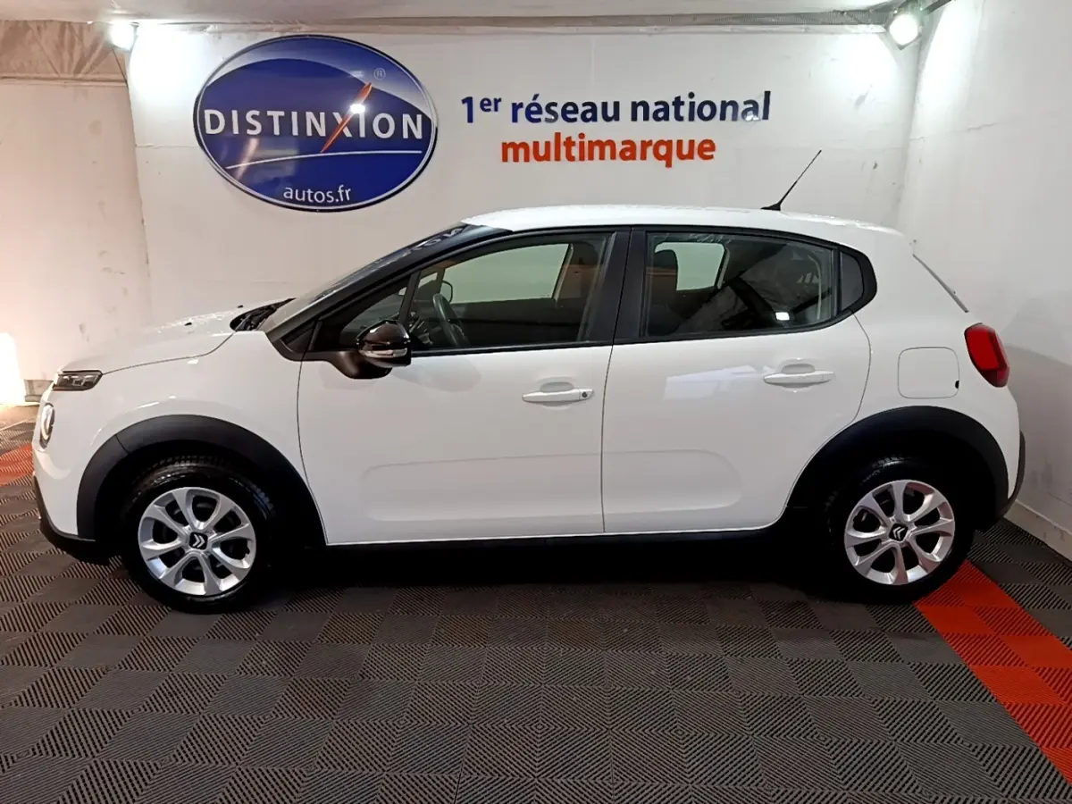 Vue de profil côté gauche d'une Citroën C3 blanche PureTech 82 S&S BVM Feel Business, avec jantes argentées et rétroviseurs noirs.