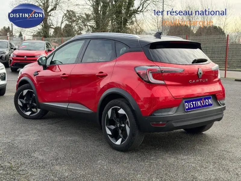 Vue 3/4 arrière droite du Renault Captur Rouge Flamme 2025 avec toit noir et jantes noires distinctives.