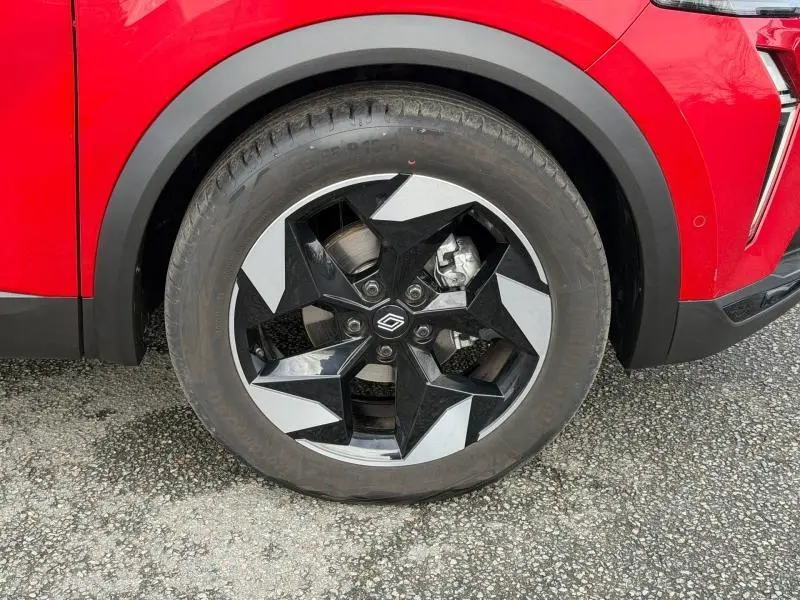 Gros plan sur la roue avant droite du Renault Captur Rouge Flamme 2025, jante noire et argentée au design géométrique.