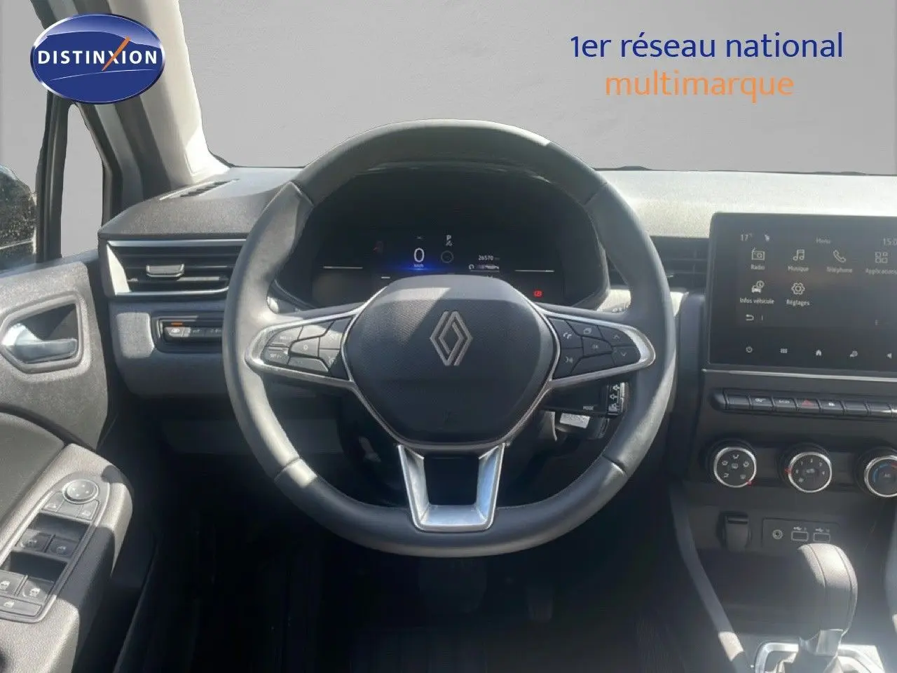 Vue intérieure centrée sur le volant noir de la Renault Clio 2025 avec tableau de bord digital et écran tactile.
