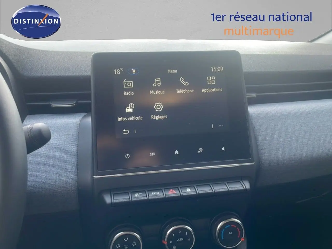Vue rapprochée de l’écran tactile central et de la console de la Renault Clio blanche, affichant le menu multimédia.