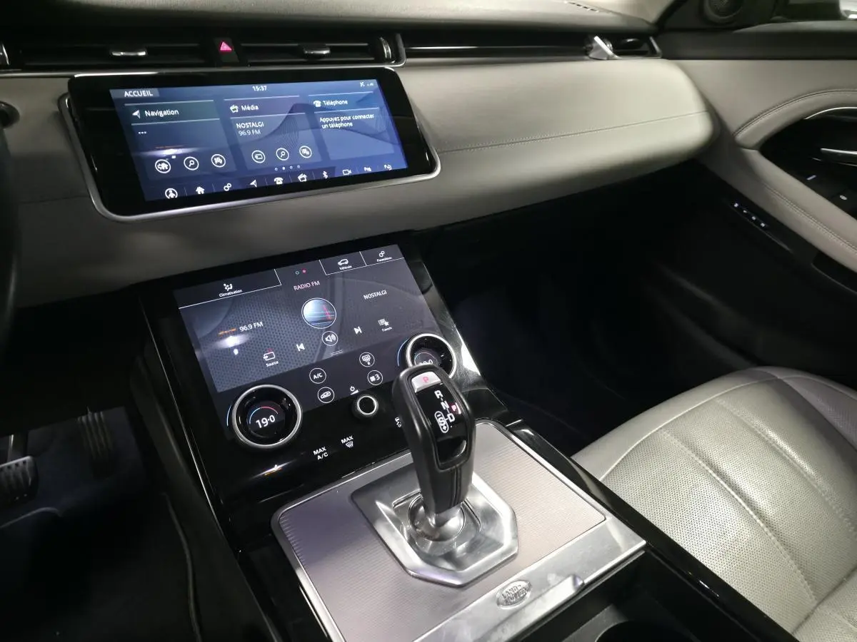 Vue intérieure du Range Rover Evoque 2019 montrant la console centrale avec levier de vitesse et écran tactile.