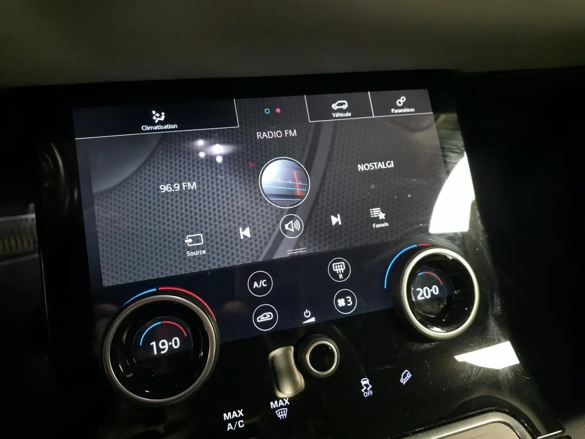 Gros plan sur l'écran tactile central et les commandes de climatisation du Range Rover Evoque 2019.
