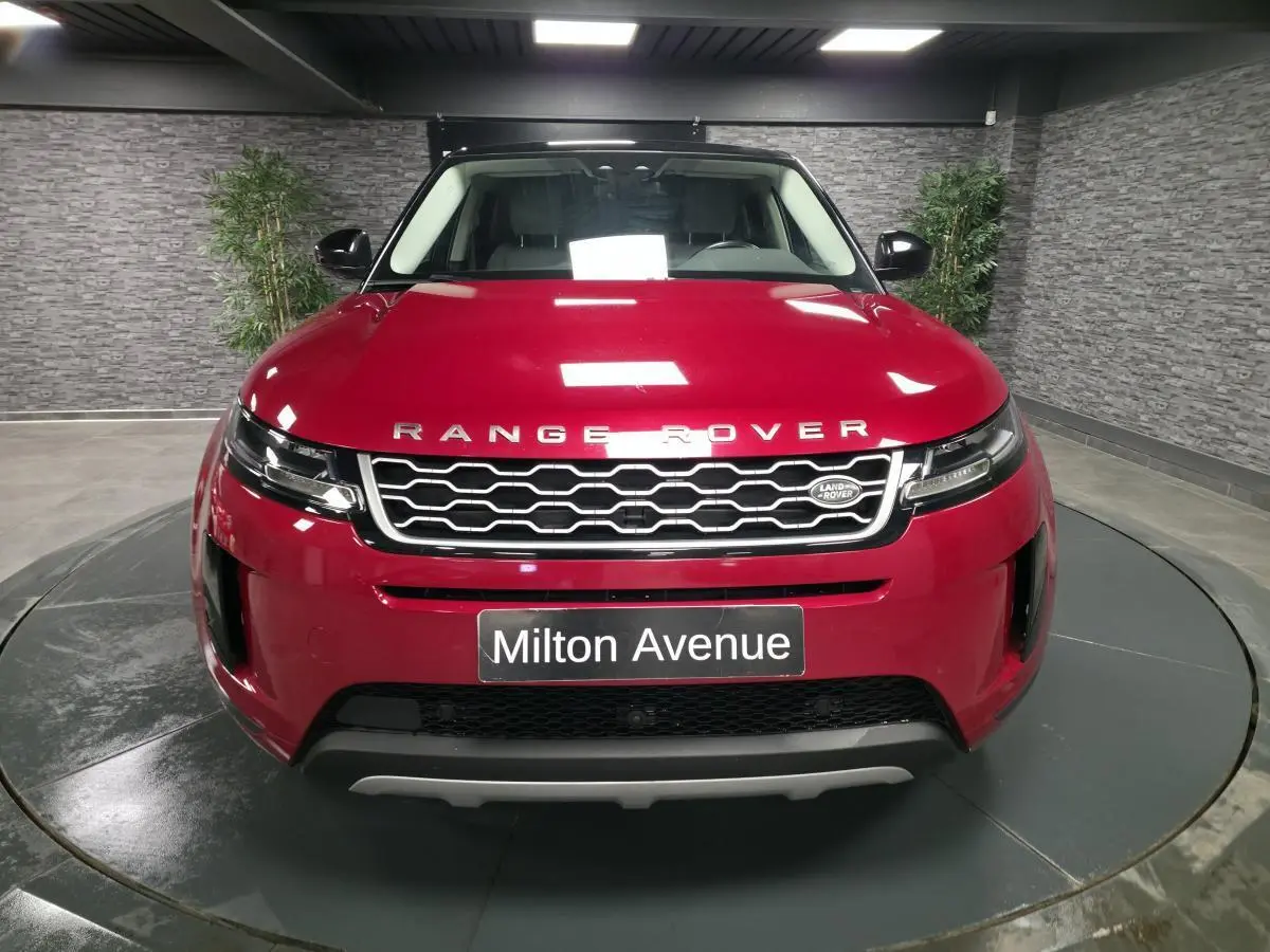 Vue avant d'un Range Rover Evoque rouge métallisé 2019 avec calandre hexagonale et logo Land Rover visible.