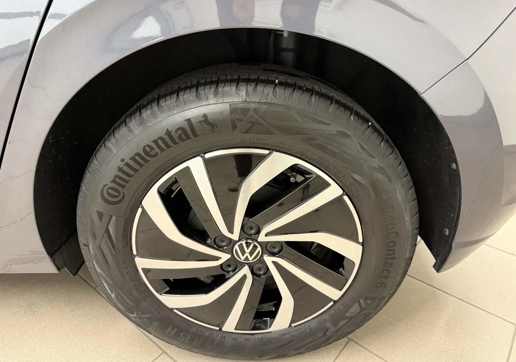 Gros plan sur la jante alliage 15'' noire et argentée d'une Volkswagen Polo gris cendre, côté arrière droit.