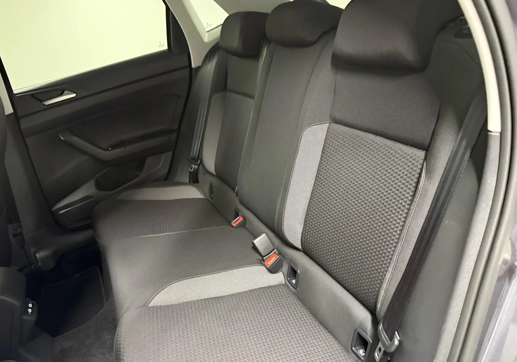 Vue intérieure côté droit de la banquette arrière tissu noir et gris du Volkswagen Polo 2025 gris cendre.