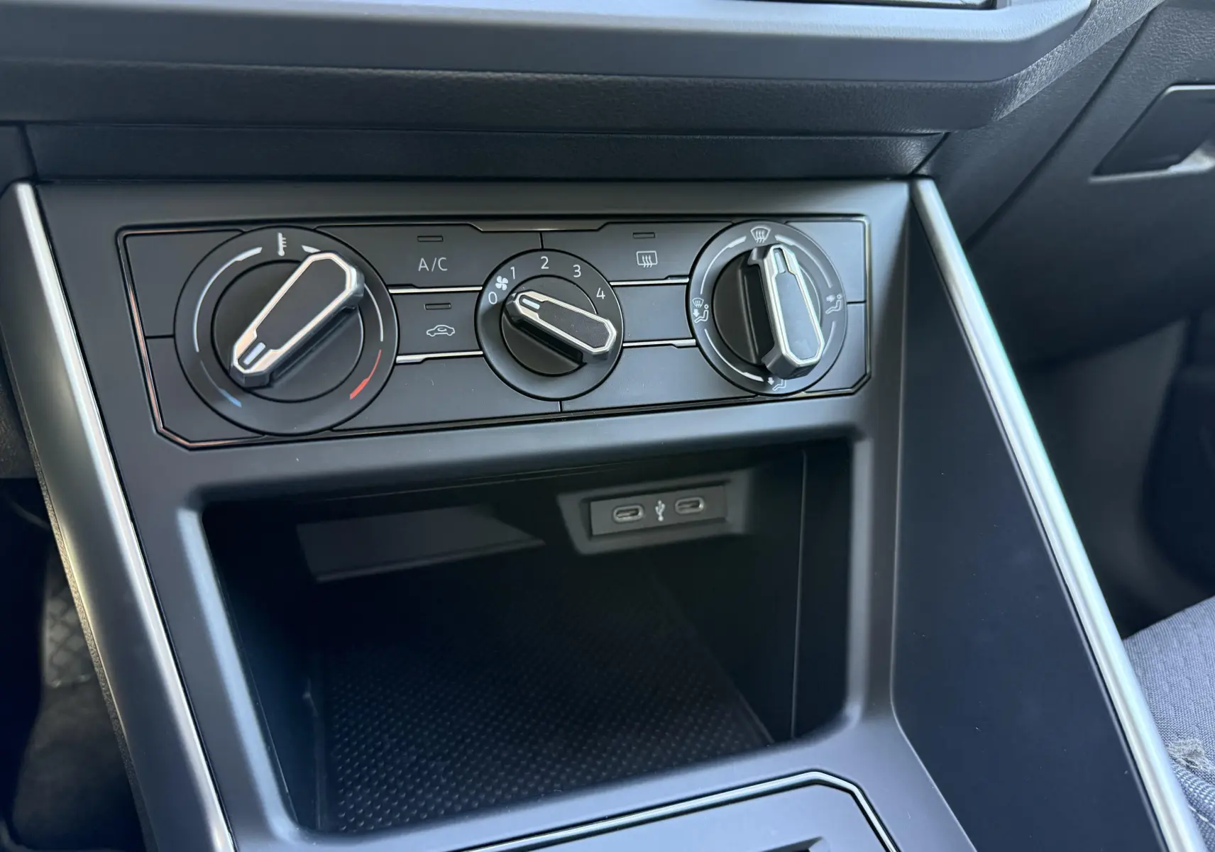 Vue rapprochée de la console centrale de la Volkswagen Polo 2025 avec commandes manuelles de climatisation et ports USB-C.