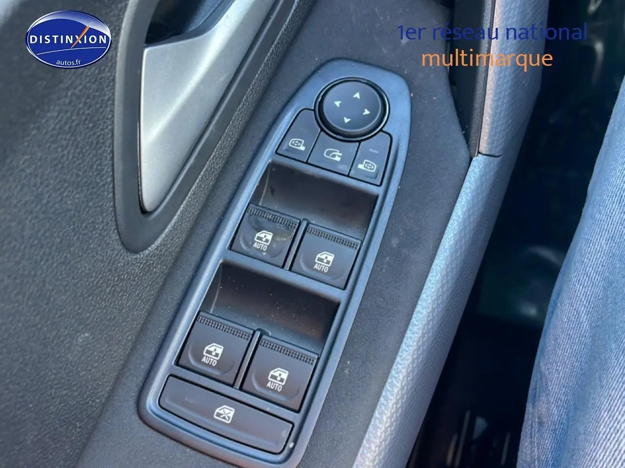 Gros plan sur les commandes des vitres électriques côté gauche d'un Dacia Duster noir, intérieur tissu gris.