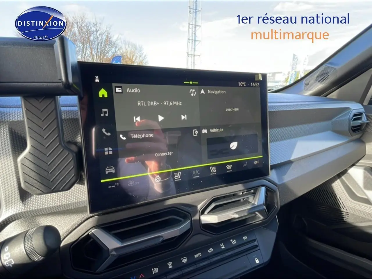Vue intérieure du tableau de bord du Dacia Duster 2026, écran tactile multifonction et aérateurs hexagonaux noirs.